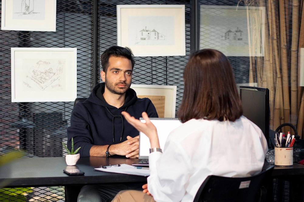 Two people in conversation across an office desk