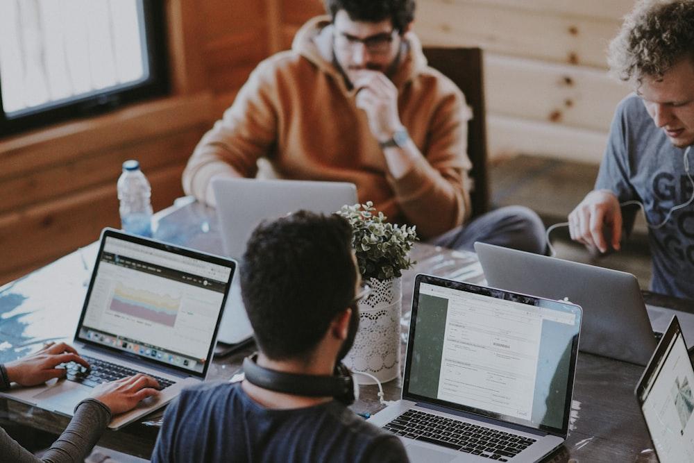 A recruiting team working at laptops around a shared table
