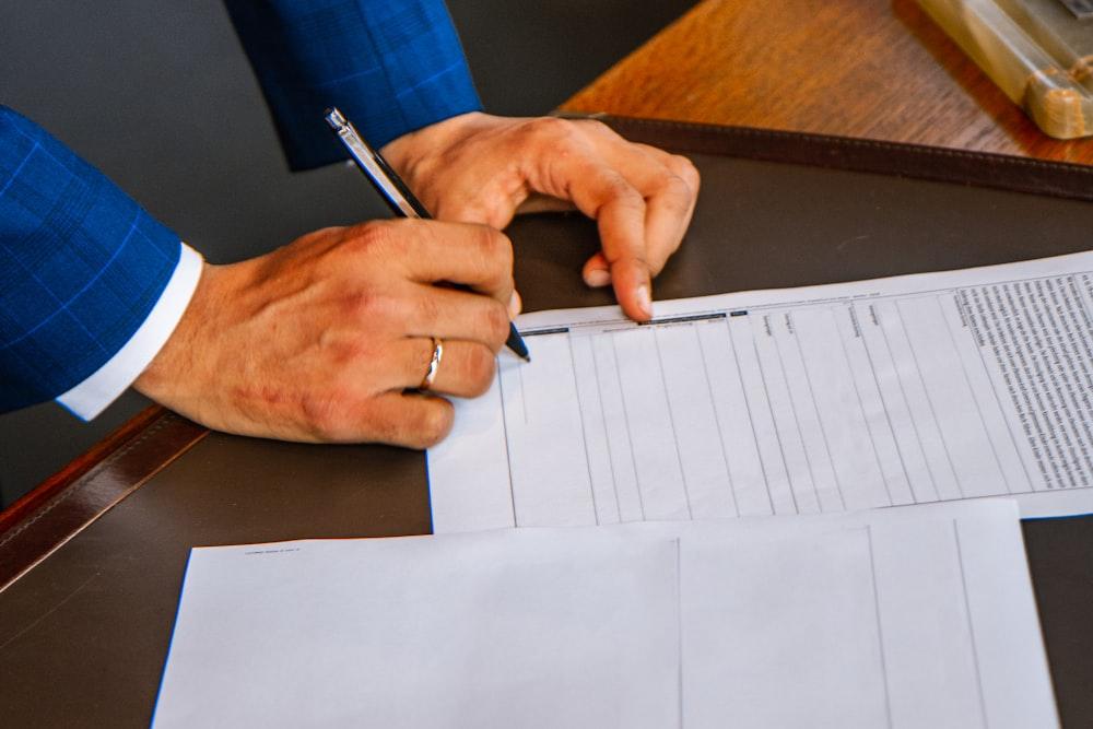 A person signing a document at a desk