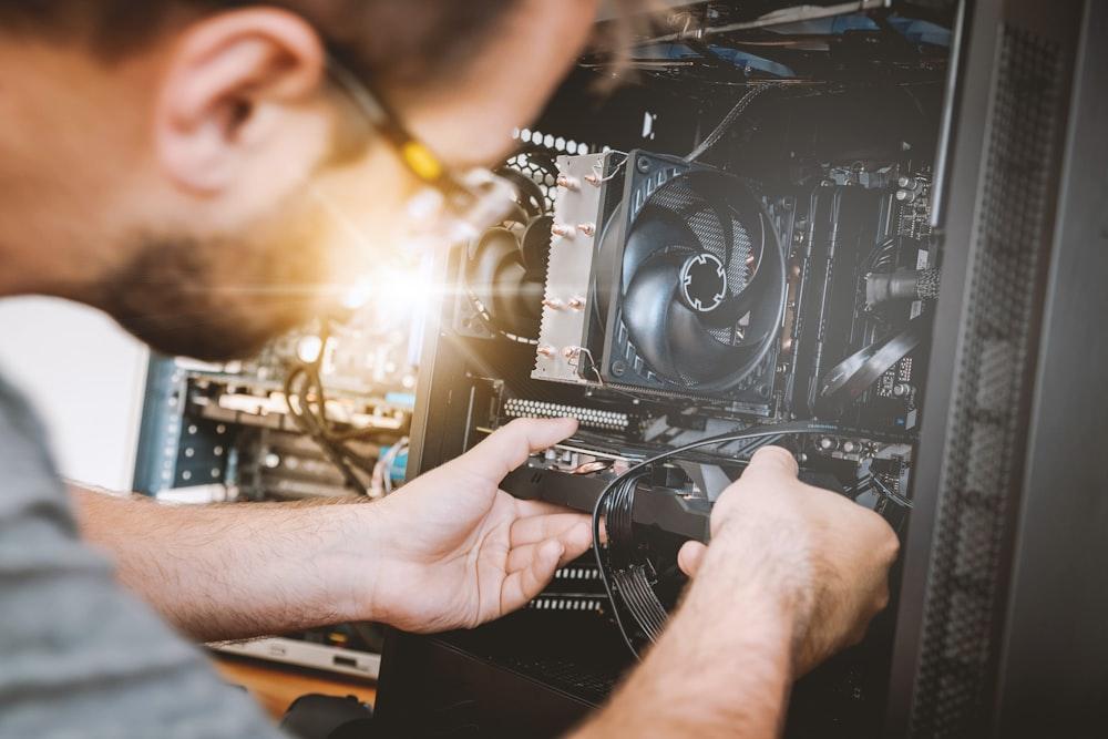 A technician working inside computer hardware