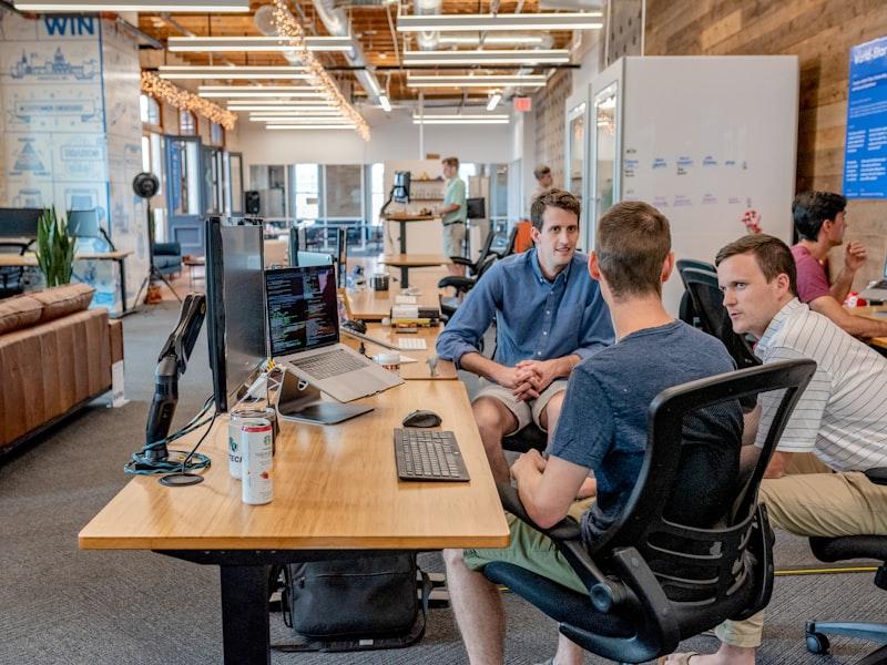 Colleagues talking over a monitor in an open-plan office
